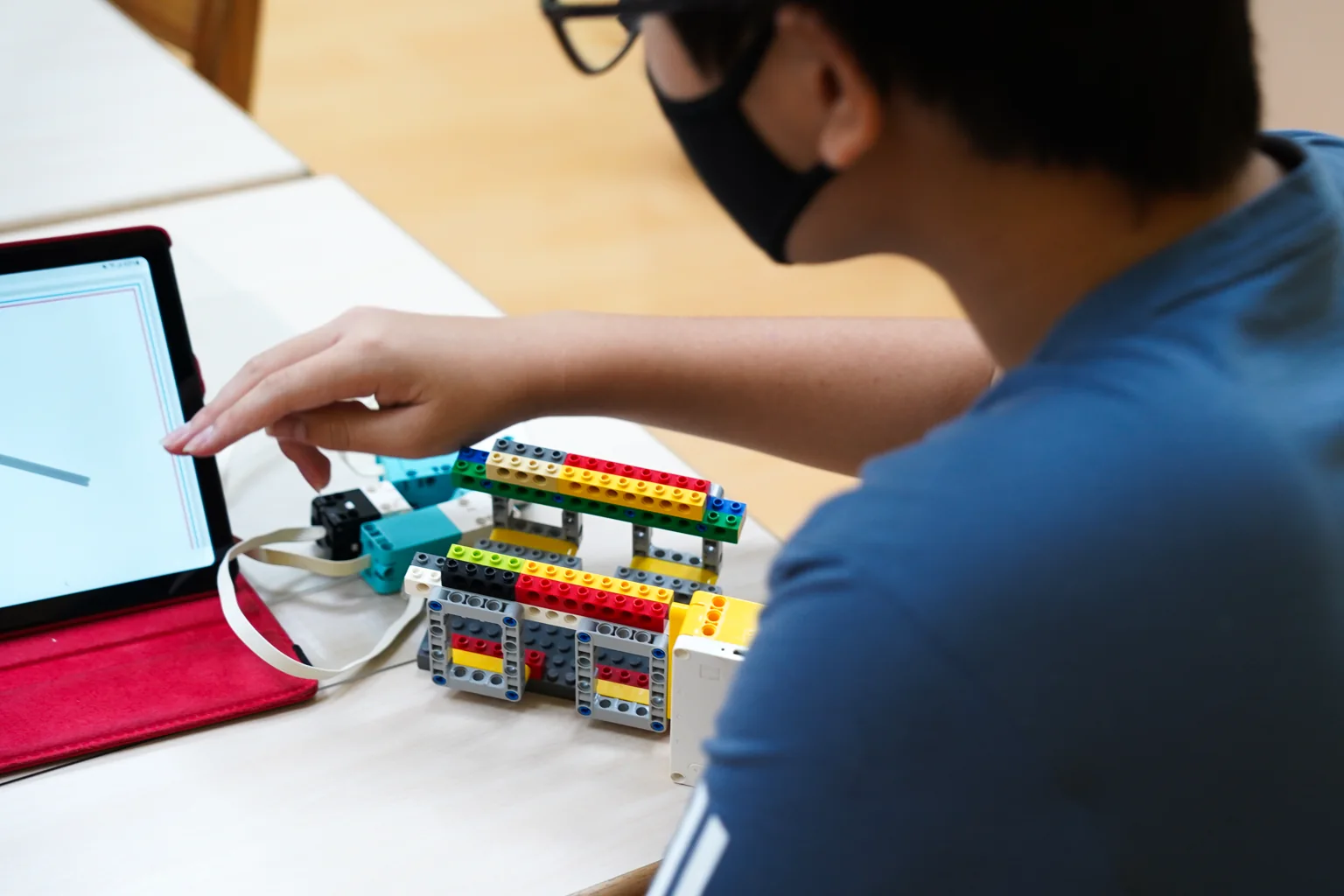Student programming a robot from a tablet