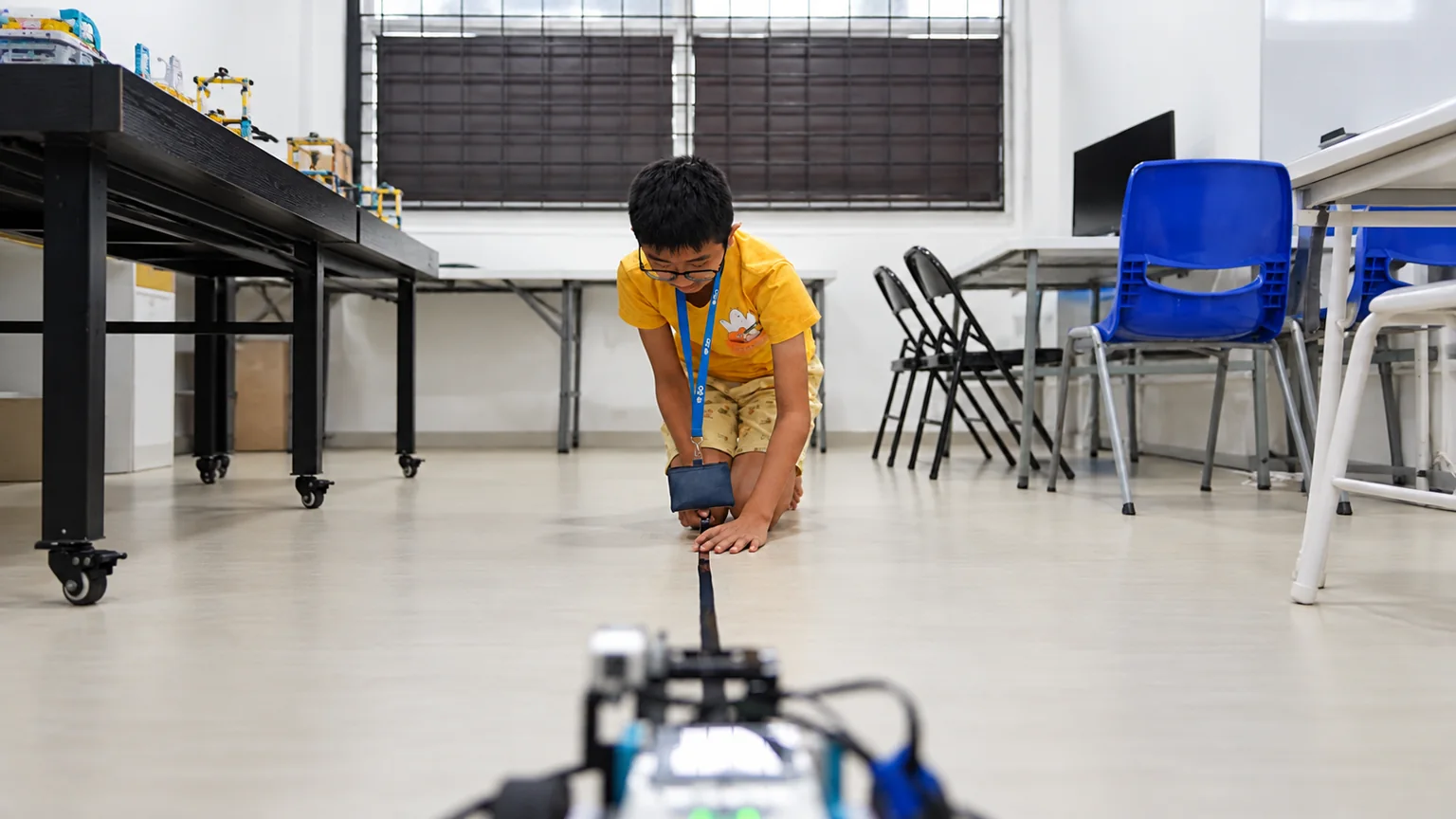 Student testing a robot in a physical challenge environment